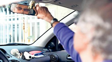 Eine Teilnehmerin des Fahrtrainings für Senioren ab 65 Jahren "Fit im Auto" stellt ihren Rückspiegel ein.