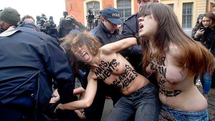 Femen-Aktivistinnen werden von der französischen Polizei am Dienstag festgenommen. Sie hatten das Auto von Dominique Strauss-Kahn erklommen. Der frühere Chef des Internationalen Währungsfonds (IWF) soll Sexpartys mit Callgirls mitorganisiert haben.