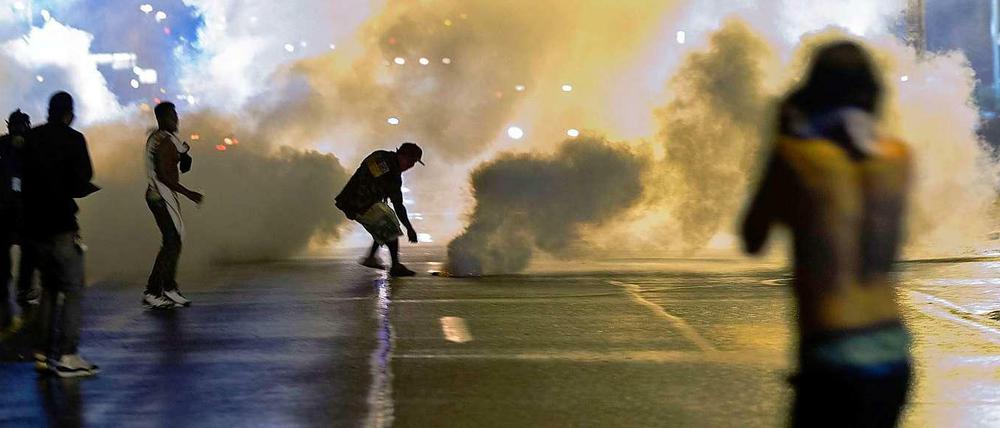 Mit Tränengas und Rauchbomben geht die Polizei gegen Demonstranten vor, die sich der von den Behörden verhängten Ausgangssperre widersetzen.