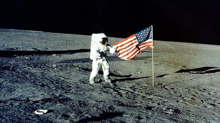 Im „Meer der Stürme“. Astronaut Charles „Pete“ Conrad posiert vor der US-Flagge. Apollo 12 war die zweite bemannte Mondlandung im Apollo-Programm.