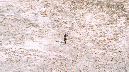 Das Bild zeigt einen Mann vom Stamm der Sentinelesen, der nach dem Tsunami auf einen Hubschrauber der indischen Küstenwache zielt. 