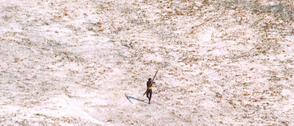 Das Bild zeigt einen Mann vom Stamm der Sentinelesen, der nach dem Tsunami auf einen Hubschrauber der indischen Küstenwache zielt. 