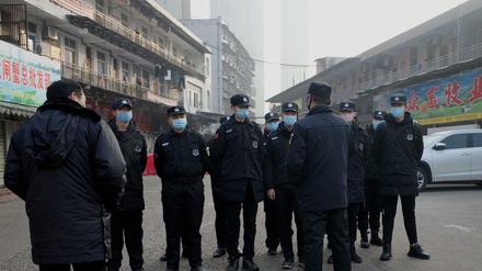 Wachleute stehen vor dem geschlossenen Fischmarkt in Wuhan. Hier war die Krankheit ausgebrochen.