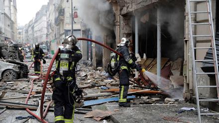 Feuerwehrleute löschen den Brand nach einer Detonation in einer Pariser Bäckerei.