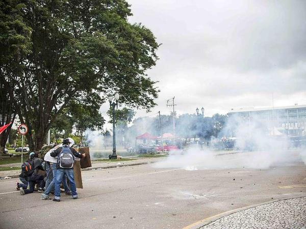 Demonstranten in Curitiba, Brasilien, suchen Schutz vor den Rauchbomben der Polizei. 