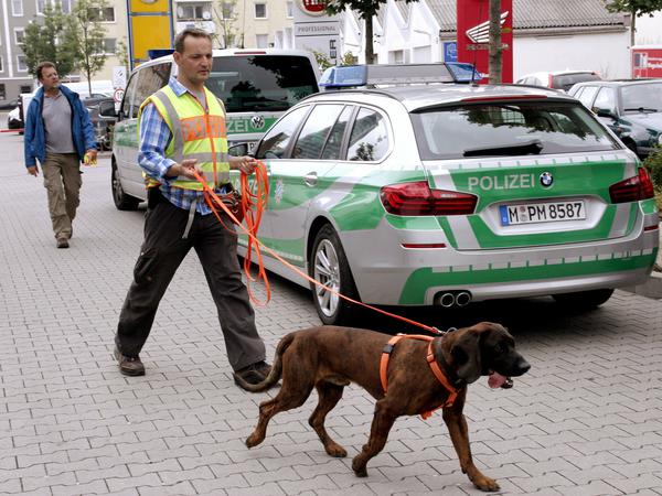 Beamte mit Hunden suchen am Mittwoch in München in der Nähe eines Supermarktes einen mutmasslichen Entführer. Die Frau eines leitenden Sparkassenmanagers war am Mittwochmorgen in ihrem Wohnhaus in Ottobrunn bei München mit einer Schusswaffe bedroht worden. Der Täter hatte den Sohn der Frau gefesselt und diese dann gezwungen, mit ihm nach München zu fahren. Dort konnte sich die Frau auf einem Supermarkt-Parkplatz befreien.