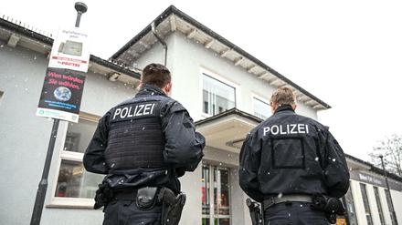 Zwei Polizisten stehen nach der Tötung einer 62-Jährigen vor dem Bahnhofsgebäude in Ravensburg.