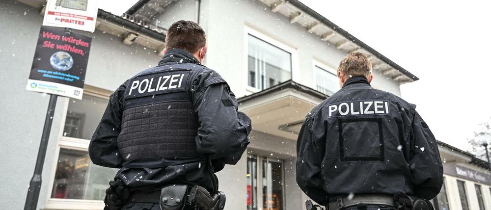 Zwei Polizisten stehen nach der Tötung einer 62-Jährigen vor dem Bahnhofsgebäude in Ravensburg.