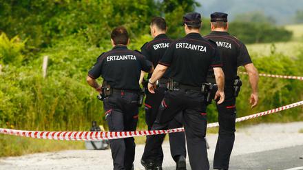 Spanische Polizisten steigen am Fundort einer Frauenleiche, nahe der Autobahn bei Asparrena, über eine Absperrung.