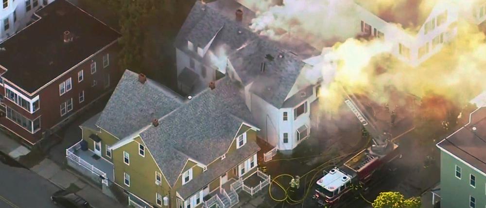 Dieses von Fernsehsender WCVB zur Verfügung gestellte Videostandbild zeigt Feuerwehrleute, die versuchen ein brennende Haus zu löschen.