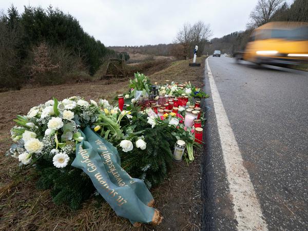 Blumen und Kerzen stehen an dem Tatort, an dem Ende Januar 2022 bei Kusel zwei Polizeibeamte bei einer Verkehrskontrolle erschossen wurden. 