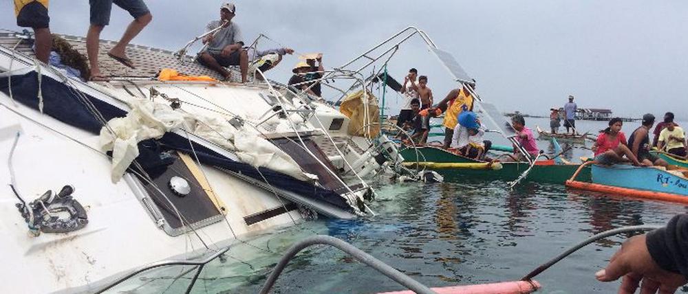 Philippinische Fischer auf dem gekenterten Boot, auf dem am Wochenende die Leiche eines Deutschen gefunden wurde.