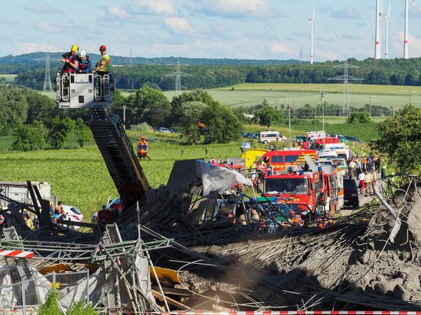 Einsatzkräfte suchen am 15.06.2016 unter einer Autobahnbrücke bei Werneck (Bayern) mit einer Wärmebildkamera nach verschütteten Personen.
