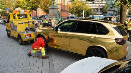 Ein goldener BMW SUV wird nahe der Düsseldorfer Königsallee abgeschleppt.