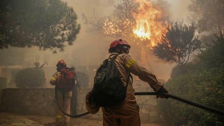 Feuerwehrleute bekämpfen einen Waldbrand in der Nähe von Athen. 