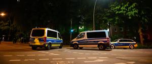 Einsatzfahrzeuge der Polizei stehen vor einem Hochhaus im Hamburger Bezirk Altona, nachdem eine Person mit einer Schusswaffe einen Großeinsatz ausgelöst hat.