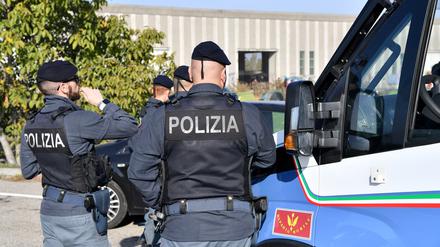 Polizisten vor einer leerstehenden Fabrikhalle in Modena, Italien (Symbolbild).