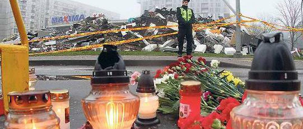 An die Toten erinnern: Vor dem zerstörten Einkaufszentrum in der lettischen Hauptstadt Riga haben Angehörige Kerzen aufgestellt. Foto: AFP
