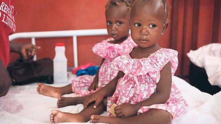 Wo die Kameras sind, sind auch die Hilfsorganisationen. Sie brauchen Bilder, vorzugsweise von Kindern, um im Kampf um den großen Spendenkuchen zu bestehen. Fotos wie dieses, mit zwei kleinen Schwestern in einem Krankenlager in Haiti, gehen um die ganze Welt.