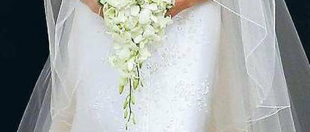 Spektakulär schlicht – echt Armani. Den Carmenkragen fürs Duchessekleid mit zehntausenden Kristallen und Perlen hatte er für Charlenes schöne Schultern komponiert. Foto: AFP
