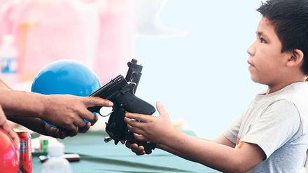 Ein Junge übergibt einem Polizisten zwei Schusswaffen – und bekommt einen Ball dafür. In der Stadt Monterrey versuchen die Behörden, der ausufernden Gewalt Einhalt zu gebieten. 40 000 Menschen starben bisher in Mexikos Drogenkrieg. 