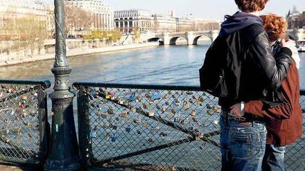 Treueschwüre. Liebespaar auf dem mit Schlössern vollgehängten Pont des Art in Paris. Foto: Pierre Hounsfield/Allpix/laif