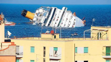 Gekentert: Das Kreuzfahrtschiff „Costa Concordia“ von der Insel Giglio vor der toskanischen Küste aus gesehen. Seit es am Freitagabend auf Felsen auflief, ist es zur Hälfte vom Wasser verschluckt worden. Die Küstenwache fürchtet, dass das völlige Versinken des Riesen nicht zu verhindern sein wird.