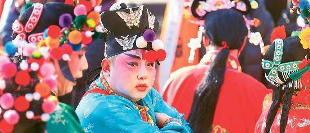 Vor dem großen Auftritt. Ein Schauspieler in traditionellem Kostüm wartet beim Neujahrsfest auf seinen Einsatz vor dem Dongyue-Tempel in Peking, der vor 700 Jahren gegründet wurde.