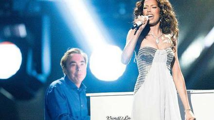 Im Hintergrund. Großbritanniens Hoffnung für den Eurovision Song Contest, Jade Ewen, begleitet Webber am Flügel. 