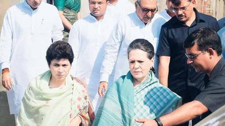 Sonia Gandhi, Chefin der mächtigen Kongresspartei (vorne rechts), besucht die Familie des Mädchens, das sich verbrannt hat. Foto: AFP
