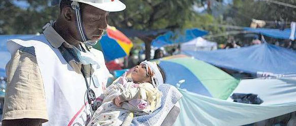 Der Helfer Jean Zacharie hat 2010 in Haiti ein Baby aus den Trümmern geborgen. Die Mutter starb bei dem Beben. Foto: Talia Frenkel/AFP