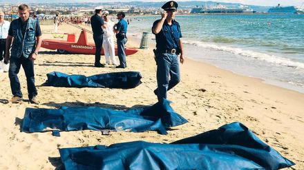 Leichen am Strand von Catania. Die ostsizilianische Stadt am Fuße des Ätna war bislang kein Anlaufpunkt für Schlepperboote aus Nordafrika. Italien versucht seit Jahren, den Flüchtlingsstrom aus dem Mittelmeer in den Griff zu bekommen. Foto: Dario Azzaro/AFP