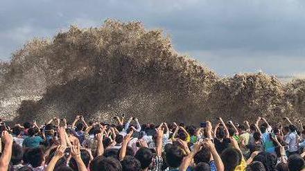 Vor dem großen Sturm. Besucher in Hangzhou fotografieren die hohen Wellen, die bereits gestern gegen die Kaimauer der Stadt schlugen. Foto: Reuters