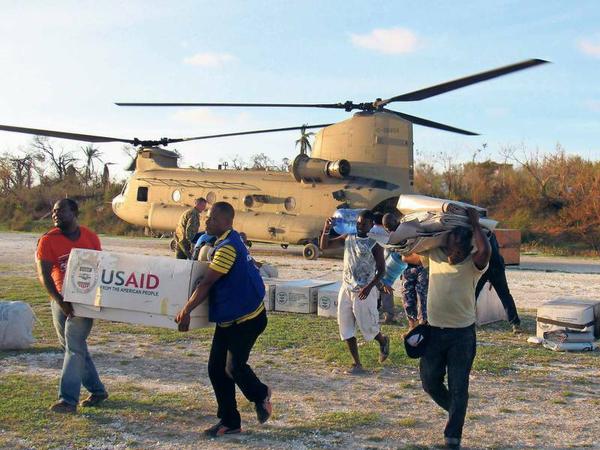 Haitianer entladen einen von den USA entsandten Hubschrauber mit dringend benötigten Nahrungsmitteln.