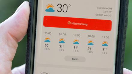Auf dem Display eines Smartphones wird eine Hitzewarnung für Deutschland vermeldet.(Archivbild)