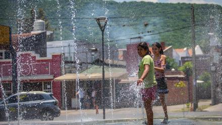 Mädchen erfrischen sich an einem Brunnen in Salta während einer heftigen Hitzewelle in Argentinien. 