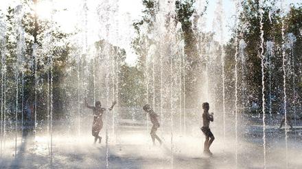 Kinder spielen in einem Brunnen in der griechischen Hauptstadt Athen.