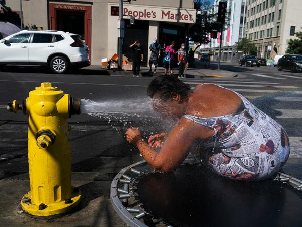 Stephanie Williams, 60, kühlt sich mit Wasser aus einem Hydranten in der Skid Row von Los Angeles ab.