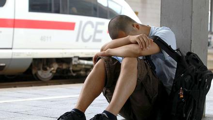 Ein junger Mann wartet auf dem Düsseldorfer Hauptbahnhof auf seinen Zug.