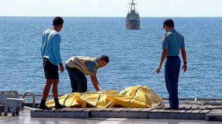 Rettungskräfte in Indonesien sichern Leichensäcke. Das Flugzeug mit der Nummer AirAsia QZ8501 war am 28. Dezember in die Javasee gestürzt. 