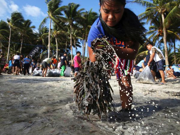 Philippiner reinigen den Strand.