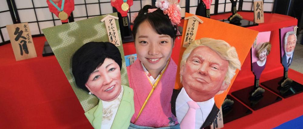 Donald Trump und Tokyos Gouverneurin Yuriko Koike auf japanischen "Glücksbringer-Paddeln". 