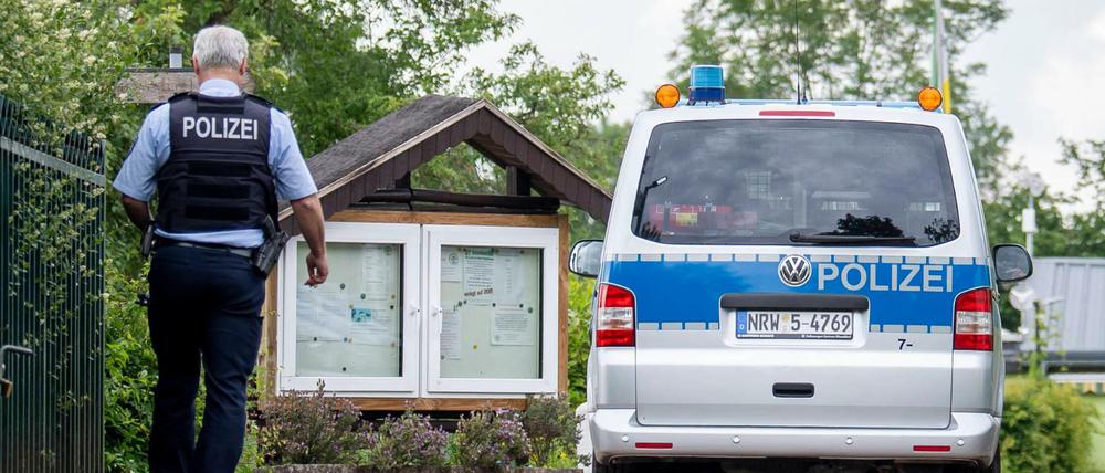 Ein Polizeiwagen fährt auf die Kleingartenanlage in Münster.