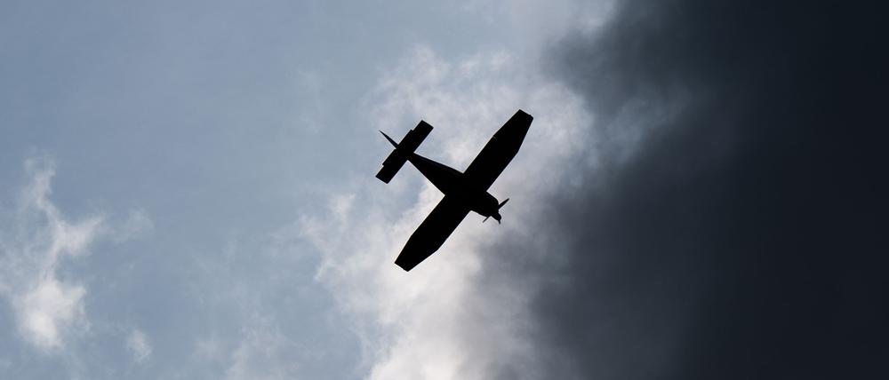 Ein Kleinflugzeug fliegt vor dunklen Wolken (Symbolbild)