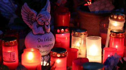 Kerzen und Blumen liegen während einer Kundgebung für den verstorbenen 22-Jährigen auf einem Spielplatz in Köthen.