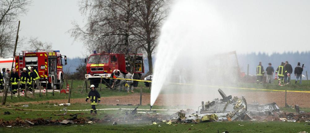 Feuerwehrleute löschen die Trümmer des abgestürzten US-amerikanischen Militärflugzeuges.