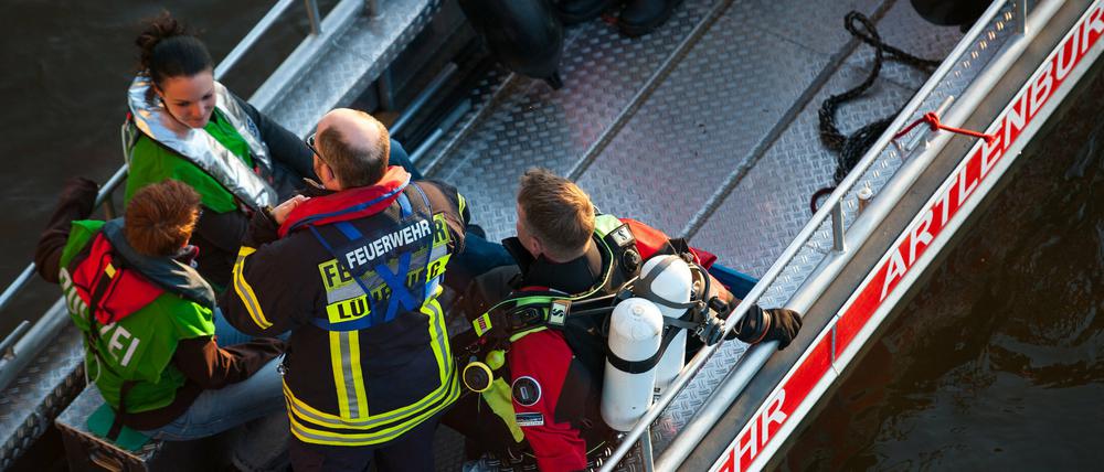 Einsatzkräfte sowie ein Feuerwehrtaucher auf der Elbe