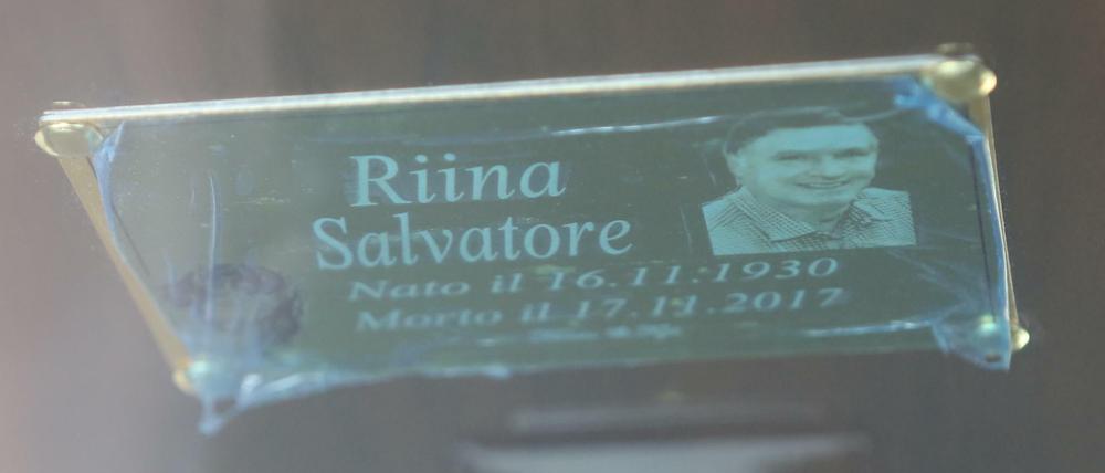 Eine Tafel mit dem Namen, den Lebensdaten von Riina auf seinem Sarg. 