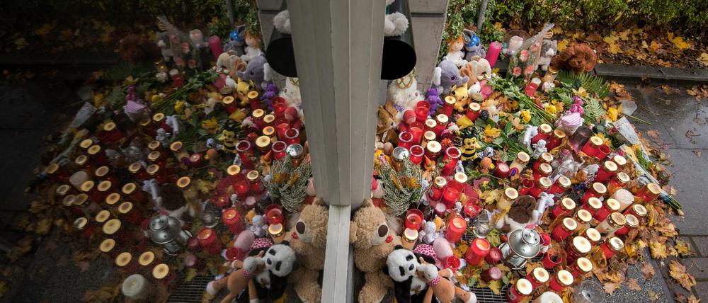 Kerzen, Blumen und Teddybären aus Stoff stehen am 25.10.2017 in Hamburg-Neuwiedenthal vor einem Mehrfamilienhaus. Nach dem Mord an einer Zweijährigen in Hamburg ist der tatverdächtige Vater in Spanien gefasst worden. 
