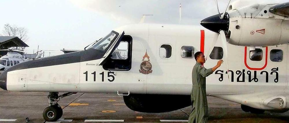Ein thailändischer Offizier prüft ein Flugzeug vor der Suche nach der verschwundenen Boeing.